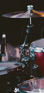 Dynamic drum set on stage with cymbals and vibrant lighting.