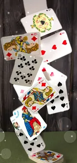 Dynamic playing cards cascade against wooden background wallpaper.