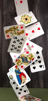 Falling playing cards on wooden backdrop.