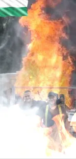 Firefighters in action with a large blaze in the background.