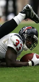 Football player in action during a game, holding the ball on the field.