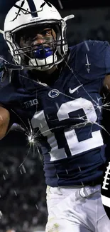 Football player in dark blue jersey in action, intense expression.