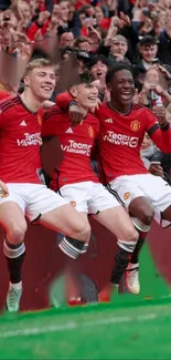 Football players celebrating in vibrant red kits on the field.