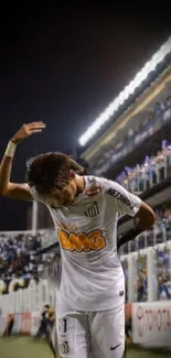 Football player celebrating on the field at night.