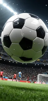 Football stadium wallpaper with soccer ball close-up, under bright lights.