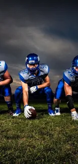 Five football players ready for action on the field at night.