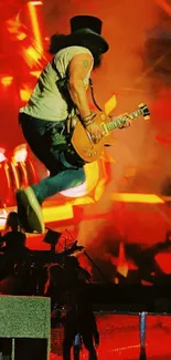 Guitarist jumps on stage with fiery lights in background.