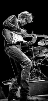 Black and white image of dynamic guitarist performing on stage.