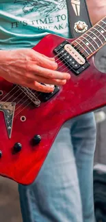 Close-up of red electric guitar being played.