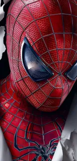 Close-up of superhero in red suit breaking through paper.