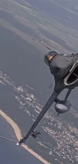 Jet flying over coastline in dynamic aerial view.