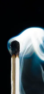 Burning matchstick with bluish smoke on a dark background.