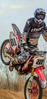 Motocross rider performing a thrilling stunt in a dynamic outdoor setting.