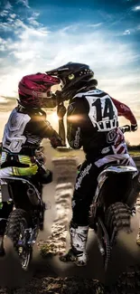 Two motocross riders at sunset with vivid skies.