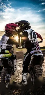 Motocross riders on dirt bikes at sunset.
