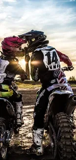 Motocross riders riding at sunset with a scenic golden sky.