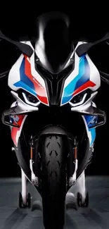 Front view of sleek, colorful motorcycle on a dark background.