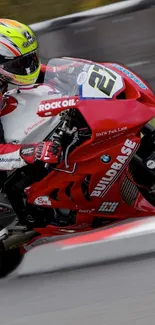 Red motorcycle racing on track with vibrant helmet and dynamic design.