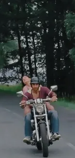 Couple riding motorcycle on scenic forest road.