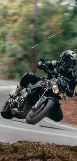 Motorcyclist taking a sharp turn on a forested road, showcasing speed and agility.