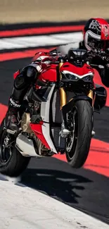 Motorcycle stunt on race track, red and black bike mid-air.