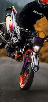 Motorcycle performing a wheelie on a colorful road during autumn.