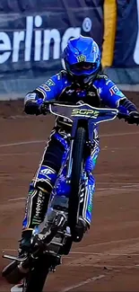Motorcycle stunt on dirt track with rider in blue gear.