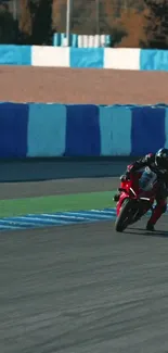 Motorcycle racing on track with blue and white barriers, capturing speed and action.