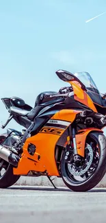 Orange and black sportbike against a clear sky.