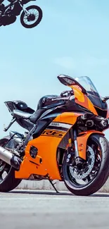 Orange motorcycle with a clear sky backdrop.