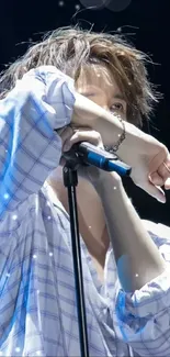 Energetic vocalist performing live under blue lights, creating concert atmosphere.