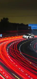 Car racing on urban road with bright red night trails.