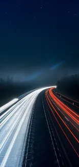 Night highway with dynamic light trails under a dark blue sky.