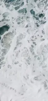 Aerial view of ocean waves with white foamy textures.