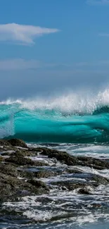 Dynamic ocean waves crashing on rocks under a turquoise sky.