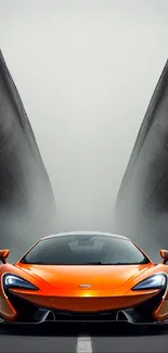 Orange sports car on a dramatic road with fog behind.