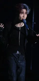 Performer passionately engaged on stage with microphone and dark attire.