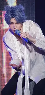 Performer on stage with vibrant blue lighting and a flowing white shirt.