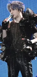 Dynamic performer in dramatic costume on a vibrant blue stage.