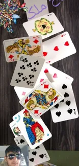 Cascading playing cards on wooden background.