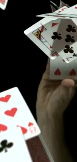 Floating playing cards on black background creating dynamic visual effect.