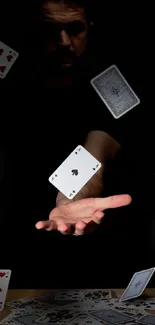 Floating playing cards on a dark background with outstretched hand.