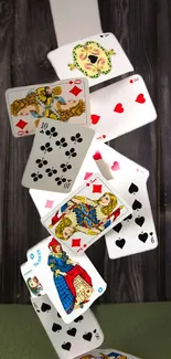 Dynamic wallpaper with playing cards cascading on wood backdrop.