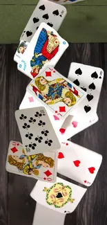 Dynamic playing cards cascading on wooden background wallpaper.