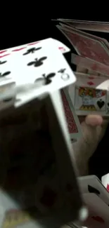 Dynamic playing cards in motion on a dark background wallpaper for mobile.