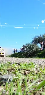 Rally car speeding on a dirt path with a scenic landscape.