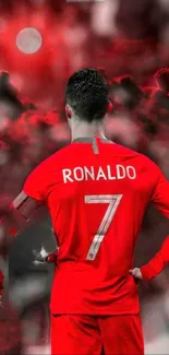 Soccer player in red jersey with a dramatic sky background.