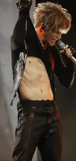 Rockstar performing energetically on stage with a microphone, wearing a leather outfit.