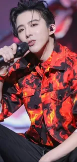 Singer on stage in a fiery red jacket during a live concert performance.