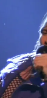 Rock singer performing under blue spotlight with microphone.